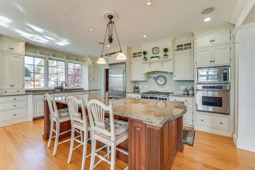 a kitchen with white cabinets and a large island with chairs at Groton Home Less Than 1 Mi to Beach on Long Island Sound! in Groton