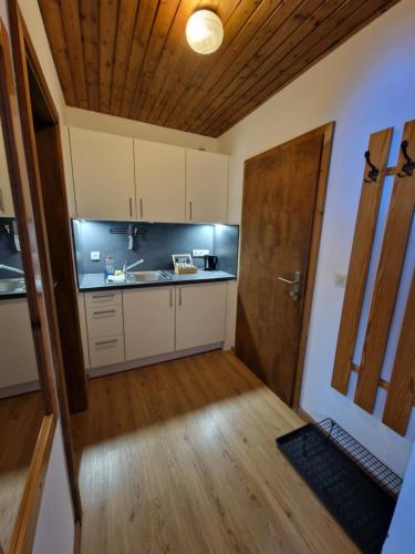 a kitchen with white cabinets and a wooden door at Garni Bärenwirt in Leutasch