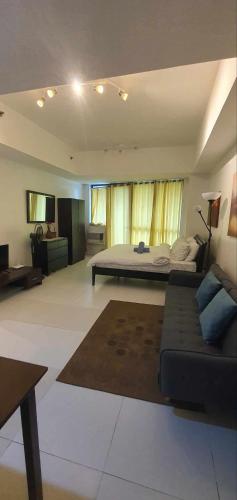 a large bedroom with a bed and a couch at KL Rooms at Greenbelt makati with cityview in Manila