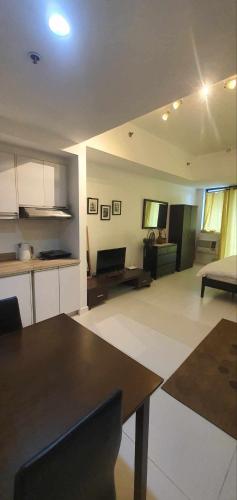 a kitchen and living room with a table and a couch at KL Rooms at Greenbelt makati with cityview in Manila