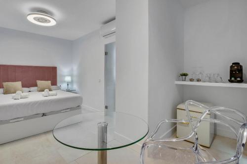 a living room with a glass table and a bed at CAMINITO REY & BANDERAS SPA Relax in Carratraca