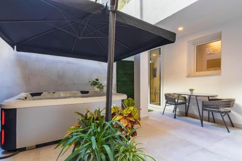 a large blue umbrella over a tub in a house at CAMINITO REY & BANDERAS SPA Relax in Carratraca