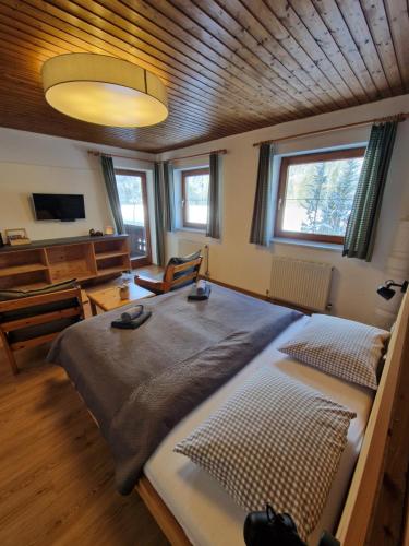 a bedroom with a large bed and a wooden ceiling at Garni Bärenwirt in Leutasch