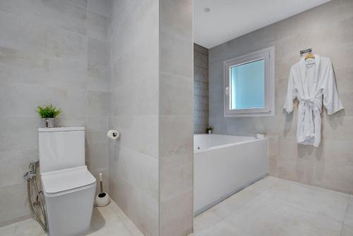 a bathroom with a toilet and a bath tub at CAMINITO REY & BANDERAS SPA Relax in Carratraca