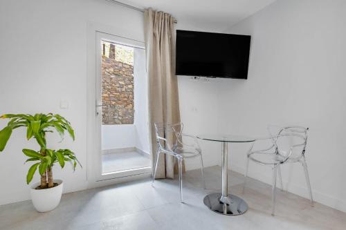 a living room with a table and a tv on a wall at CAMINITO REY & BANDERAS SPA Relax in Carratraca