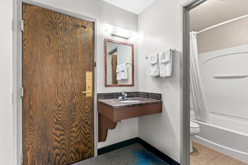 a bathroom with a sink and a mirror at Days Inn by Wyndham Sioux Falls in Sioux Falls
