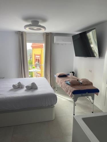 a bedroom with a bed and a table and a tv at CAMINITO REY & BANDERAS SPA Relax in Carratraca