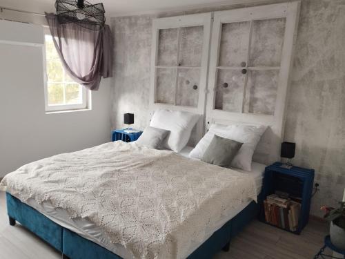 a bedroom with a bed with white sheets and pillows at Villa Evetes in Jablonov nad Turnou