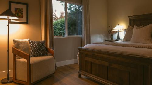a bedroom with a bed and a chair and a window at Folsom Old Town Escape in Folsom