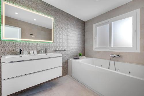 a bathroom with a white tub and a large mirror at CAMINITO REY & BANDERAS SPA Relax in Carratraca