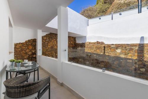 a dining room with a table and a stone wall at CAMINITO REY & BANDERAS SPA Relax in Carratraca