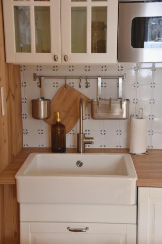 une cuisine avec un évier blanc et un évier dans l'établissement Chez Colette - Appartement à la montagne, à Demi-Quartier