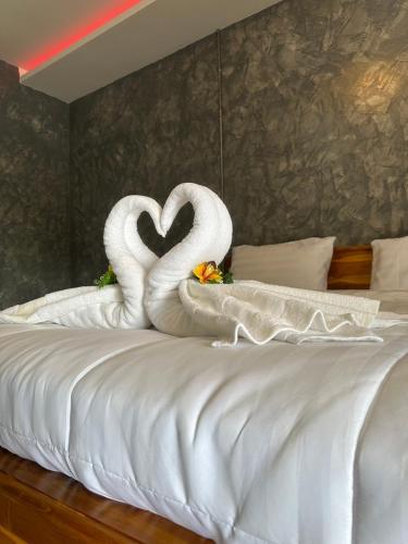 two swans making a heart on a bed at J House Has Love in Sukhothai