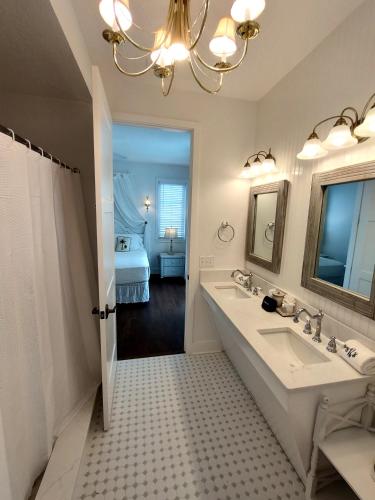 a bathroom with two sinks and a mirror and a bed at Bungalow Beach Resort in Bradenton Beach