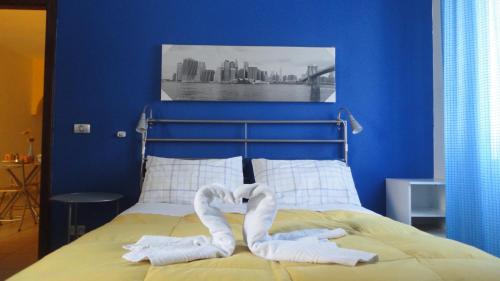 a bed with two pairs of white towels on it at Travel and Living in Trani