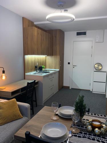 a living room with a table and a kitchen at Apartman Glečer Vila Bela Reka in Brzeće