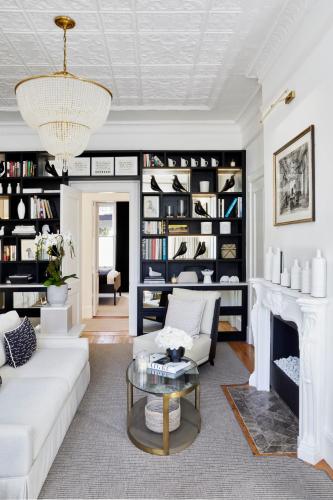 a living room with a white couch and a fireplace at âmé by NOAH in Cape Town