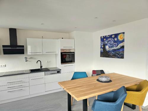 cocina con mesa de madera y sillas azules en Sanosueno 5, en Sonthofen