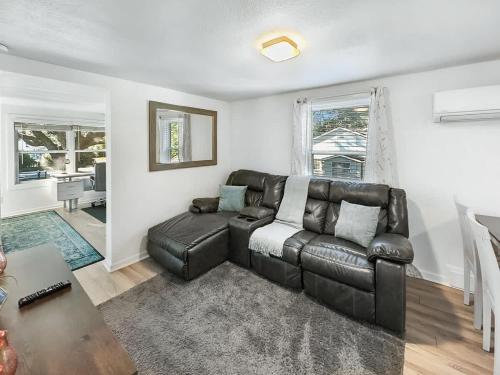 a living room with a leather couch and a table at Golf Course-Front 2-Bedroom Apartment in Charleston