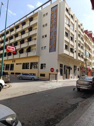 a large white building with cars parked in front of it at Appartement Hamria RiF in Meknès