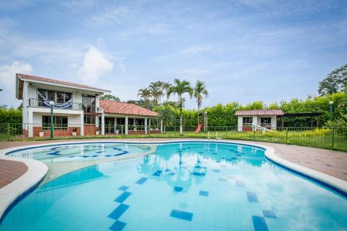 a swimming pool with a house in the background at Hotel Chalet La Sofia by Majuva in Armenia