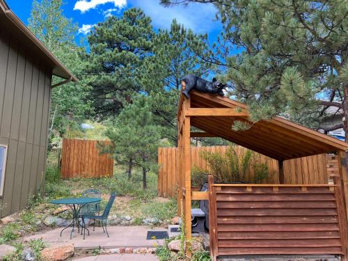 a black bear sitting on top of a wooden roof at Bear House - EV #3073 in Estes Park