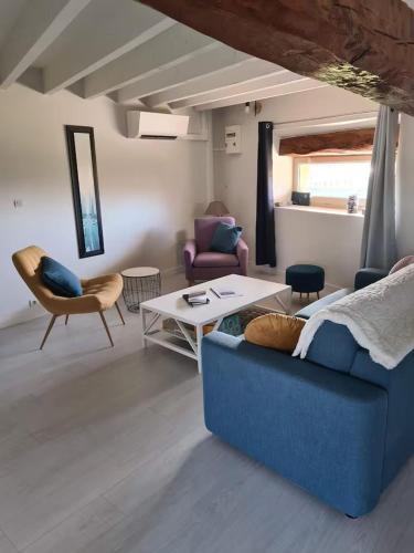 un salon avec un canapé bleu et une table dans l'établissement La Grande Hogue, à Dragey-Ronthon