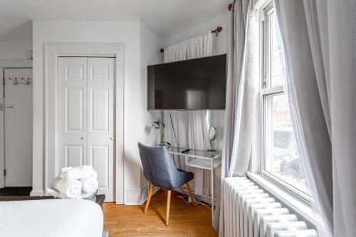 a bedroom with a bed and a desk and a window at Sunshine Room by harbor downtown beach I-95&Train in Stamford