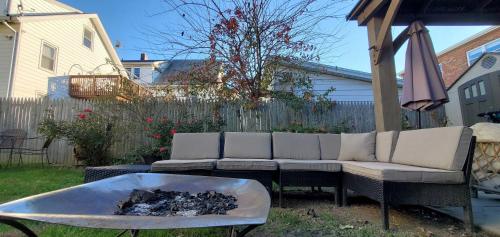 a couch and a fire pit in a yard at Sunshine Room by harbor downtown beach I-95&Train in Stamford