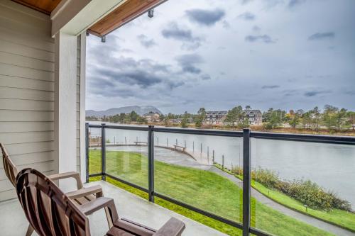 a balcony with two chairs and a view of the water at Herons View at Bridgeport - Meredith Lodging in Seaside