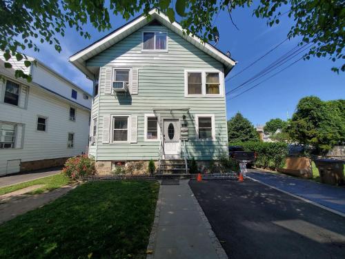 a white house with a white door on a street at Sunshine Room by harbor downtown beach I-95&Train in Stamford