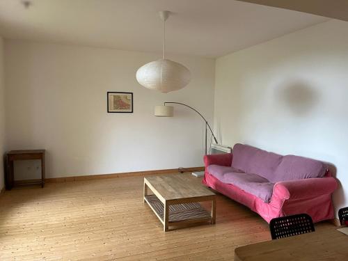 un salon avec un canapé violet et une table dans l'établissement Maison de campagne - proche Bordeaux, à Saint-Vincent-de-Paul