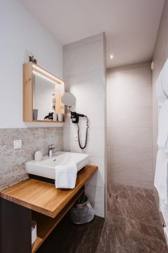 a bathroom with a white sink and a mirror at Landhotel Laudersbach in Altenmarkt im Pongau