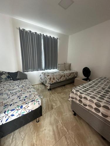 una camera da letto con due letti e una finestra di Caueira Casa Beach - Gomes & Lima a Itaporanga dʼAjuda