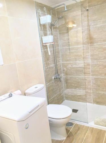 a bathroom with a toilet and a shower at Bright & spacious with aircon in Puerto del Carmen