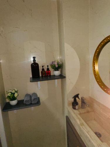 ein Badezimmer mit Waschbecken und einem Regal an der Wand in der Unterkunft Résidence du bonheur in Abidjan