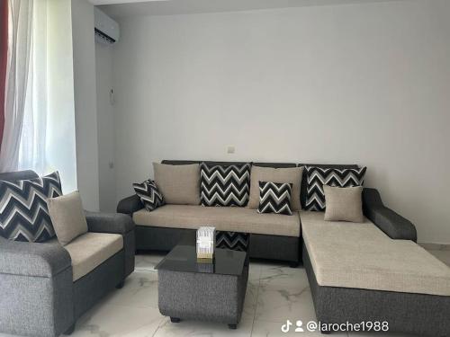 ein Wohnzimmer mit Sofa und Tisch in der Unterkunft Résidence du bonheur in Abidjan