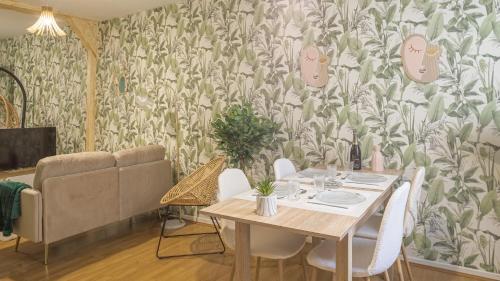 - une salle à manger avec une table, des chaises et du papier peint dans l'établissement Amazonia 1 - Hypercentre - 2 pers, à Troyes