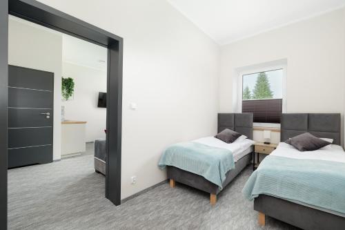 a bedroom with two beds and a mirror at KAJNET Resko in Resko