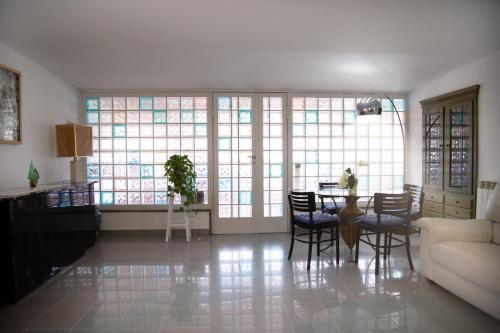 a living room with a table and chairs and windows at Casa Petito - Casa Vacanze in Giugliano in Campania