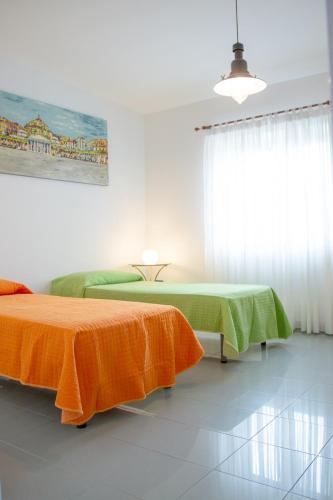 a bedroom with two beds with orange and green sheets at Casa Petito - Casa Vacanze in Giugliano in Campania