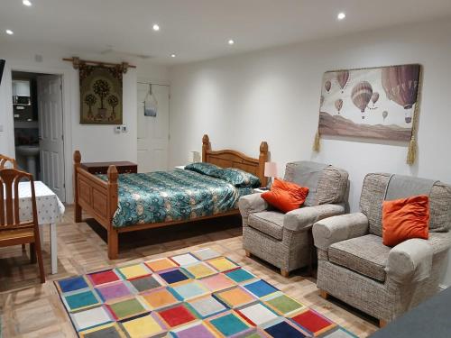 a bedroom with a bed and a couch and a chair at Railway Retreat No4 Comberton Terrace in Kidderminster
