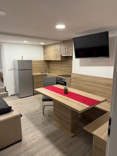 a kitchen with a table and a television on the wall at Kamrca na Kopah in Šmartno pri Slovenj Gradcu