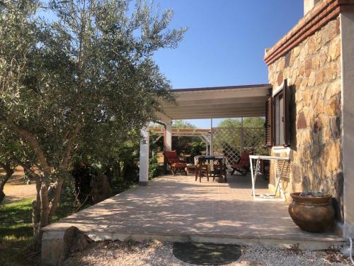 a patio of a house with a table and chairs at NicChia Turchese in Orosei