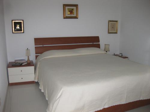 マリーナ・ディ・ラグーザにあるCasa Vacanze Le Roseのベッドルーム1室(大きな白いベッド1台、ナイトスタンド2台付)