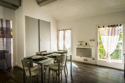 a dining room with a table and chairs and a window at Appt Cosy et chaleureux - La crinière in Le Poët