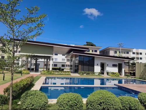 an exterior view of a building with a swimming pool at JTropics Plumera Mactan Near Airports, Malls and Beaches in Lapu Lapu City