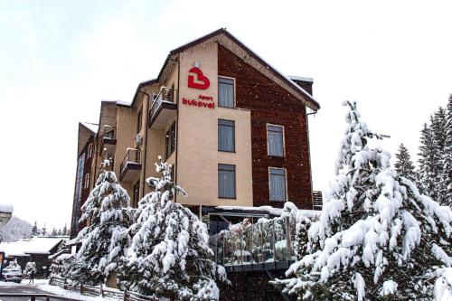 a hotel with snow covered trees in front of it at Bukovel Apart in Bukovel