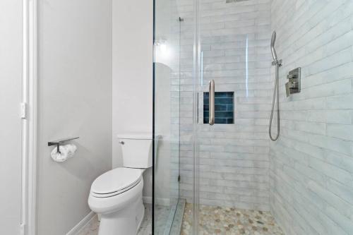 a bathroom with a toilet and a glass shower at Sunrise in Paradise-BeachFront-Fenced Yard-Pets-Sleeps 11 in Galveston