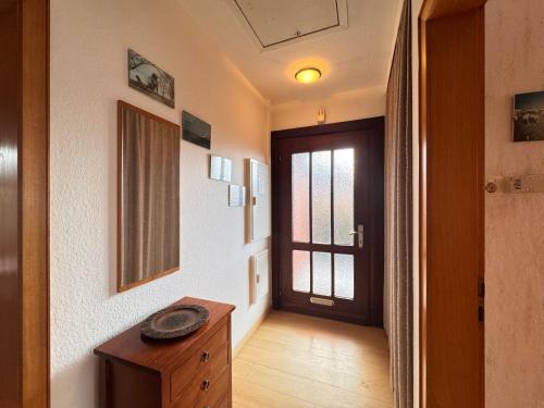 - un couloir avec une porte et une table en bois dans une chambre dans l'établissement Ferienhaus Krüger, à Schillig